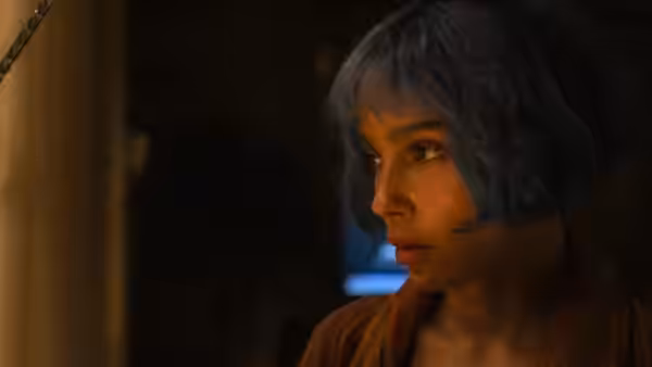 Angela Childs (Zoë Kravitz) gazing to the side in a dimly lit room