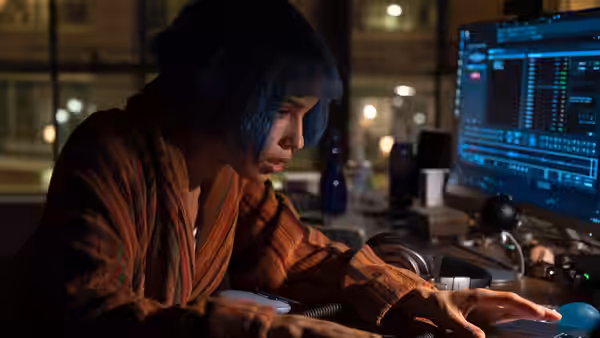Angela Childs (Zoë Kravitz) working at her computer desk at night
