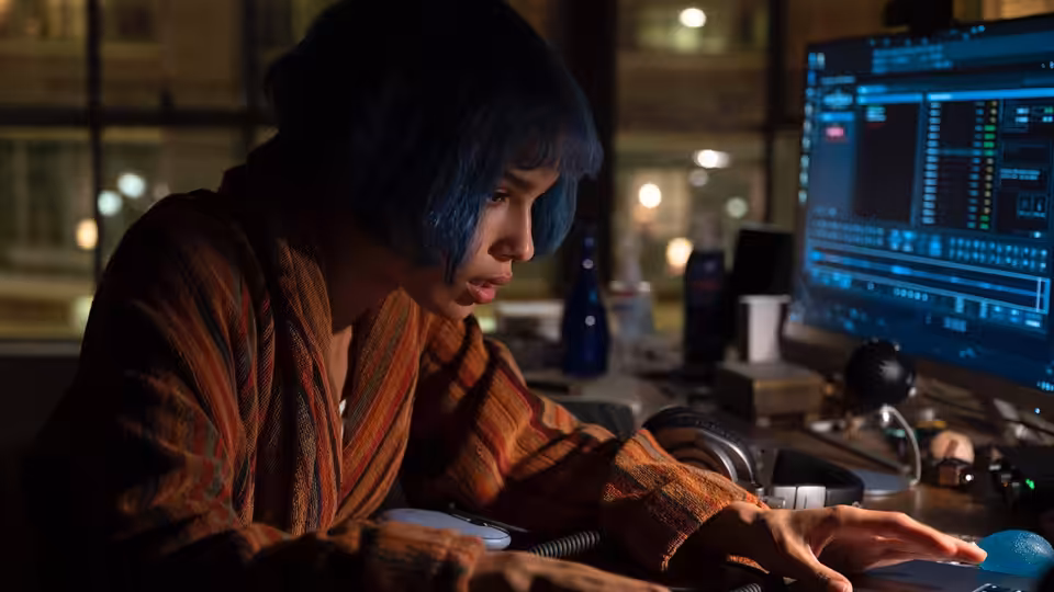 Angela Childs (Zoë Kravitz) working at her computer desk at night