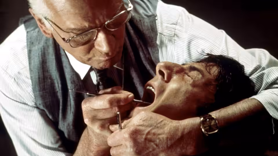 Dr. Christian Szell (Laurence Olivier) leaning over Thomas 'Babe' Levy (Dustin Hoffman) with dental tools in his mouth