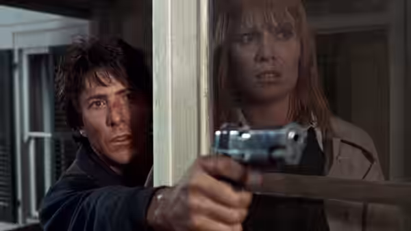 Thomas 'Babe' Levy (Dustin Hoffman) and Elsa Opel (Marthe Keller) looking out while holding a revolver
