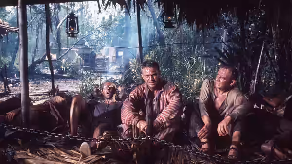 Papillon (Steve McQueen) and Louis Dega (Dustin Hoffman) chained inside a jungle hut