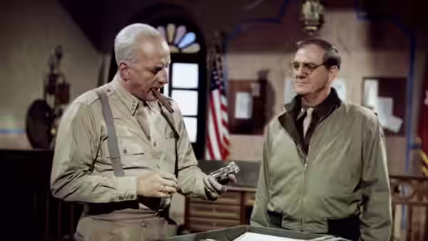 Two officers examining a handgun inside a military office