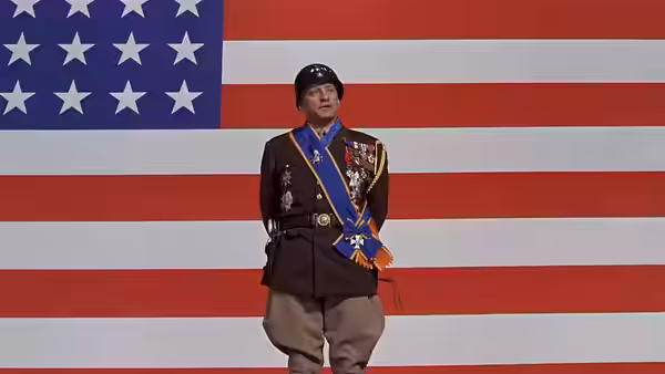 General Patton standing before a large American flag