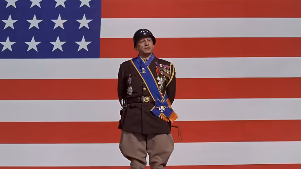 General Patton standing before a large American flag