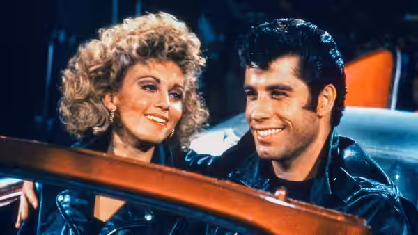 Rizzo (Stockard Channing) sits beside Kenickie (Jeff Conaway) in a car
