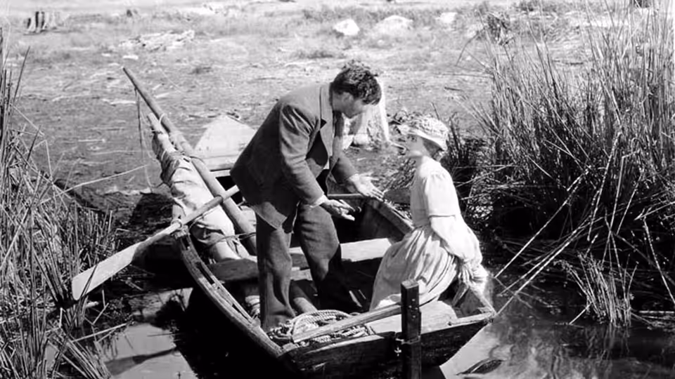 The Man (George O'Brien) and the Wife (Janet Gaynor) balance in a small boat among reeds