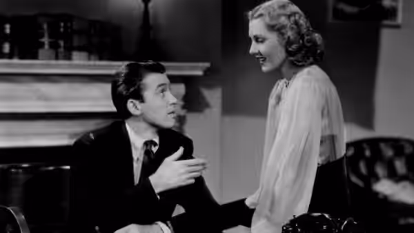 Jefferson Smith (James Stewart) and Clarissa Saunders (Jean Arthur) talking closely indoors