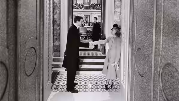 Jefferson Smith shaking hands with a woman in an ornate marble corridor