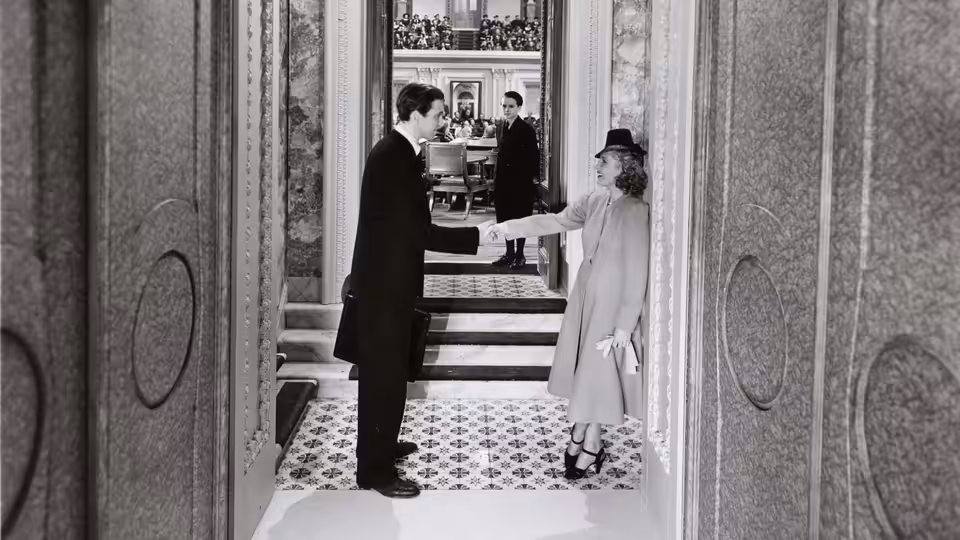 Jefferson Smith shaking hands with a woman in an ornate marble corridor