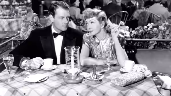 Tom Jeffers (Joel McCrea) and Gerry Jeffers (Claudette Colbert) sit together at a restaurant table