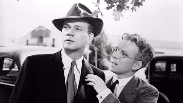 Charlie Oakley (Joseph Cotten) standing with Herbie Hawkins (Hume Cronyn) outdoors