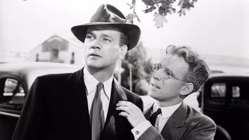 Charlie Oakley (Joseph Cotten) standing with Herbie Hawkins (Hume Cronyn) outdoors