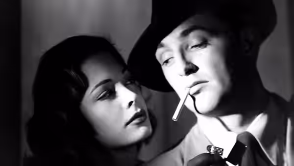 Kathie Moffat (Jane Greer) leans close to Jeff Bailey (Robert Mitchum) with a cigarette