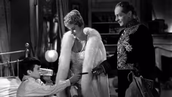 Lisa Berndle (Joan Fontaine) and Stefan Brand (Louis Jourdan) watch a boy with a toy gun