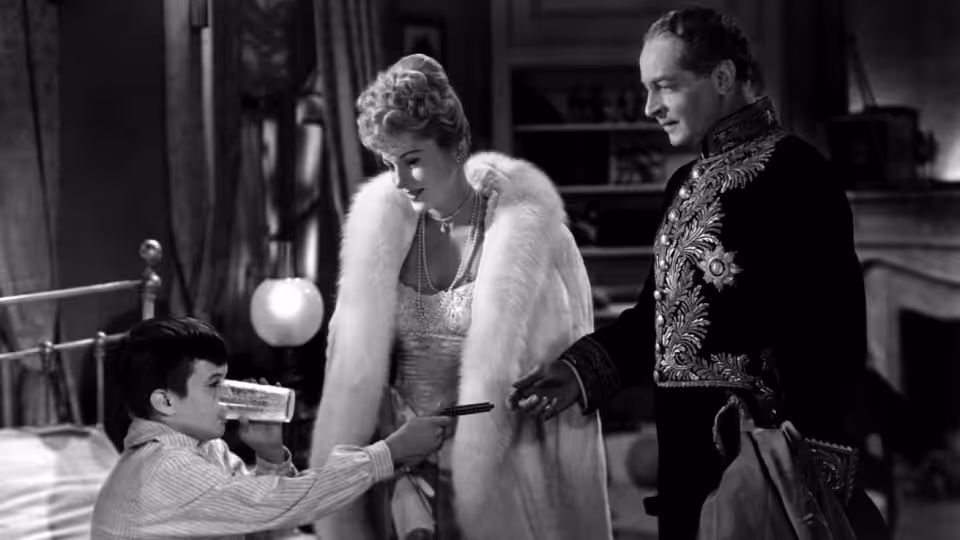 Lisa Berndle (Joan Fontaine) and Stefan Brand (Louis Jourdan) watch a boy with a toy gun