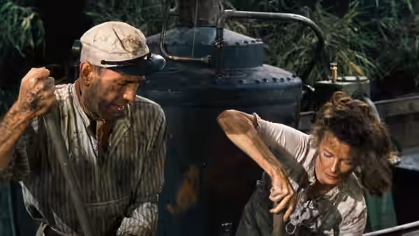 Charlie Allnut (Humphrey Bogart) raising his fist near the boiler with Rose Sayer