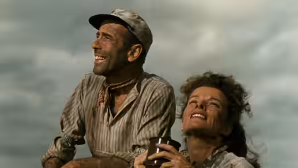 Charlie Allnut (Humphrey Bogart) and Rose Sayer (Katharine Hepburn) smiling up at the sky