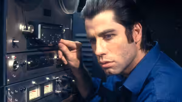 Jack Terry (John Travolta) adjusting controls on audio equipment in a studio