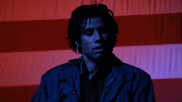 Jack Terry (John Travolta) standing in front of an American flag at night