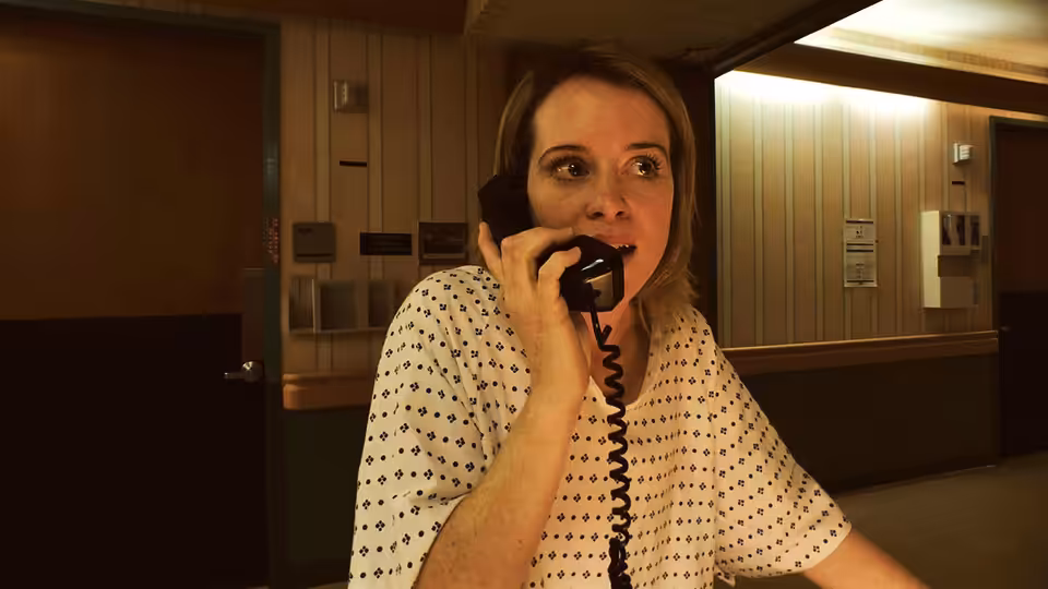 Sawyer Valentini (Claire Foy) speaking on a phone in a hospital hallway
