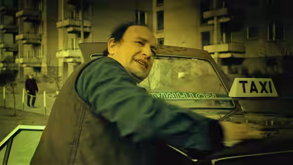 Waldemar Rekowski (Jan Tesarz) leaning from his taxi at night