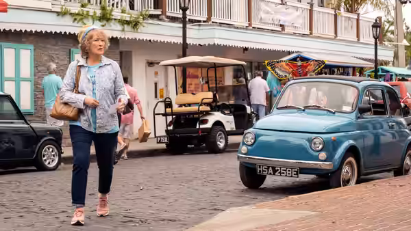 Ellen Martin (Meryl Streep) walking past a blue car on a busy street