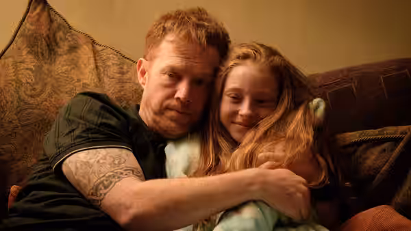 Ricky (Kris Hitchen) embraces his daughter Liza Jane (Katie Proctor) on the sofa