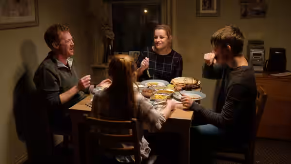 Ricky (Kris Hitchen), Abby (Debbie Honeywood), and their children share a meal around the dining table