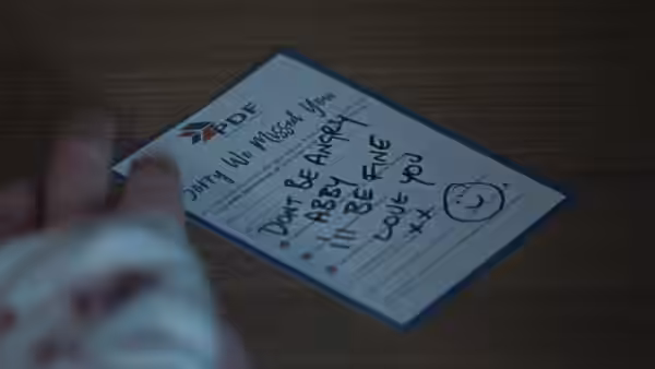 A handwritten note on a delivery company card wishes someone good luck