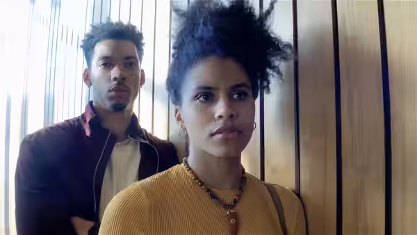 A young woman with an afro hairstyle standing before a young man