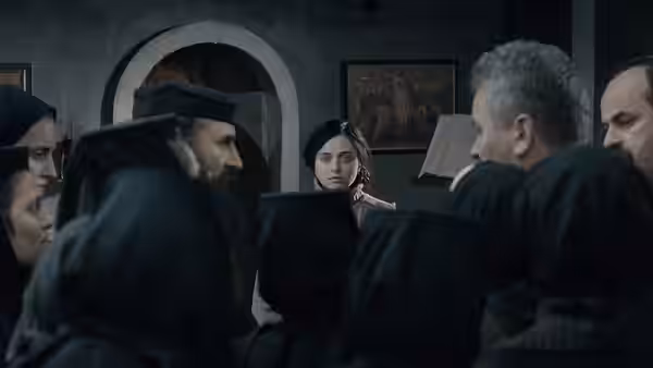 A young woman stands surrounded by robed figures in a dimly lit church