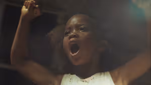 Hushpuppy with arms raised and mouth open looking upward