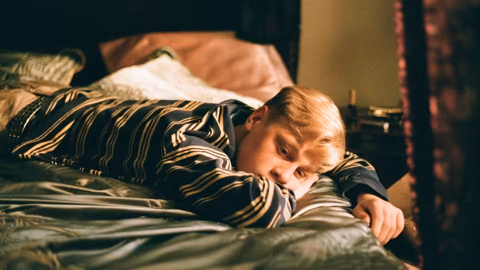 Steve (Antoine Olivier Pilon) lying on a bed looking toward the camera