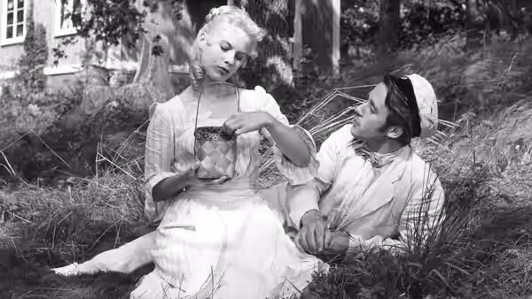 Sara (Bibi Andersson) sits in a garden beside a young man in a sailor cap