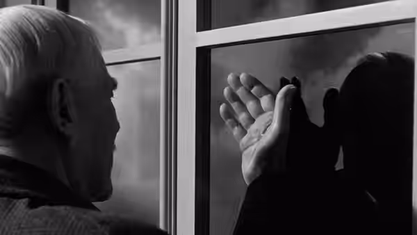 Professor Isak Borg (Victor Sjöström) raises his hand toward a mirror