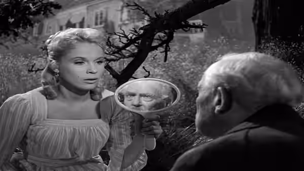 Sara (Bibi Andersson) holds a hand mirror toward Professor Isak Borg (Victor Sjöström)