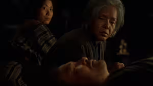 Orin (Sumiko Sakamoto) looking down at an elderly person lying in darkness