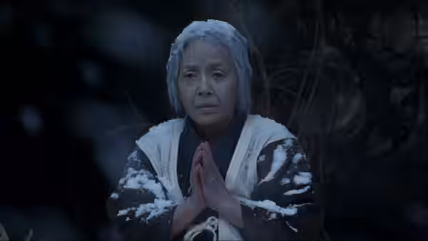 Orin (Sumiko Sakamoto) kneeling in the snow with hands clasped before her