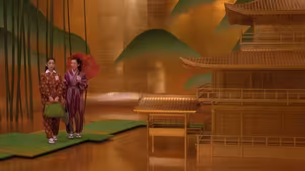 two figures in traditional robes stand on green mats before a golden screen and pagoda model