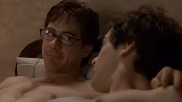 Terry Crabtree (Robert Downey Jr.) lying in bed beside another man