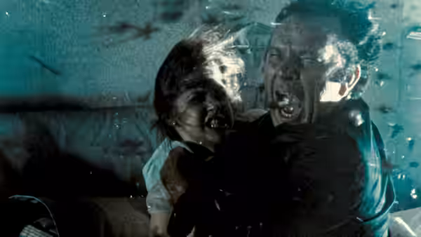 A young girl and a man scream while drenched in water and debris