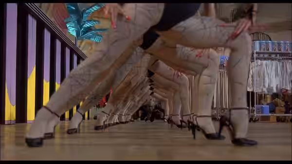 Dancers in patterned stockings executing synchronized high kicks on a polished floor