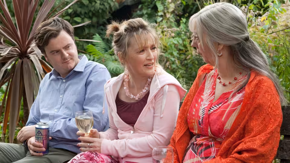 Joe, Mary and Gerri sitting together outdoors with drinks in hand