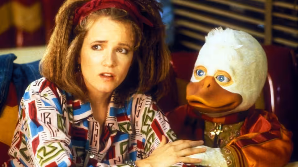 Beverly Switzler (Lea Thompson) sits with Howard the Duck on a couch