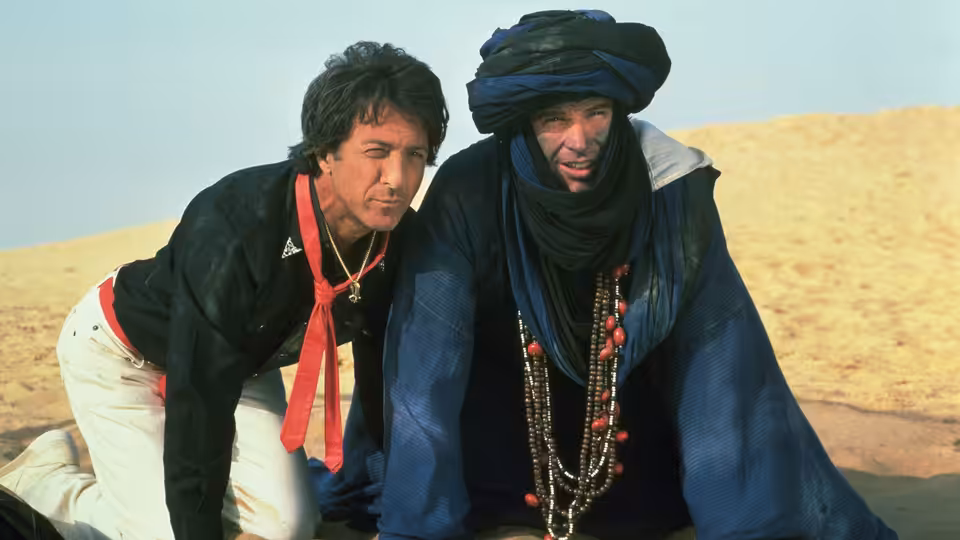 Lyle Rogers (Warren Beatty) and Chuck Clarke (Dustin Hoffman) kneeling together in the desert
