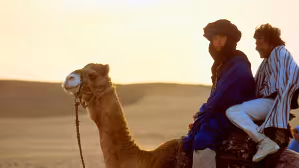 Chuck Clarke (Dustin Hoffman) and Lyle Rogers (Warren Beatty) riding a camel at sunset