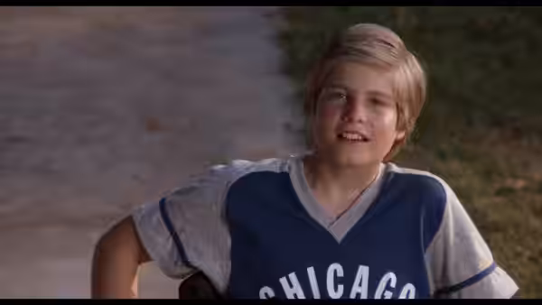 Smiling boy in a Chicago sports jersey sits outdoors