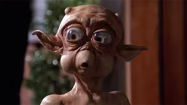 Small alien creature stares with wide eyes and open mouth