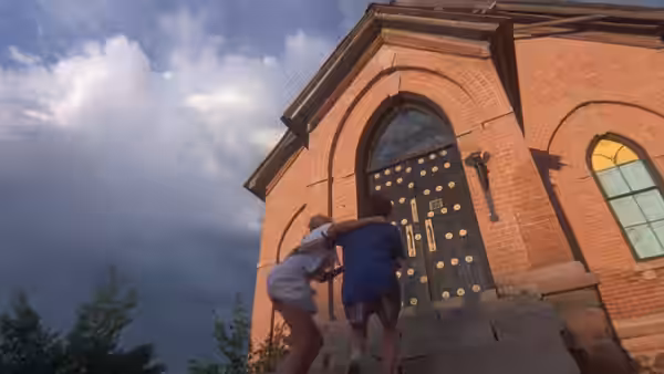 Two children run up steps toward the doors of a brick building
